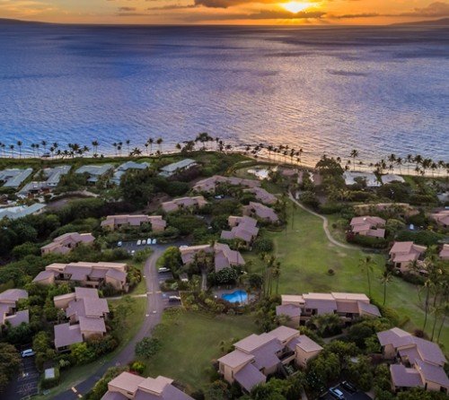 Sunset over a low-rise resort neighborhood and the ocean in South Maui